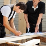 Ausbildung Handwerk - Meister zeigt Auszubildendem Holzarbeiten