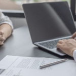 Bewerbungsgespräch - 2 Hände am Laptop + Vertrag